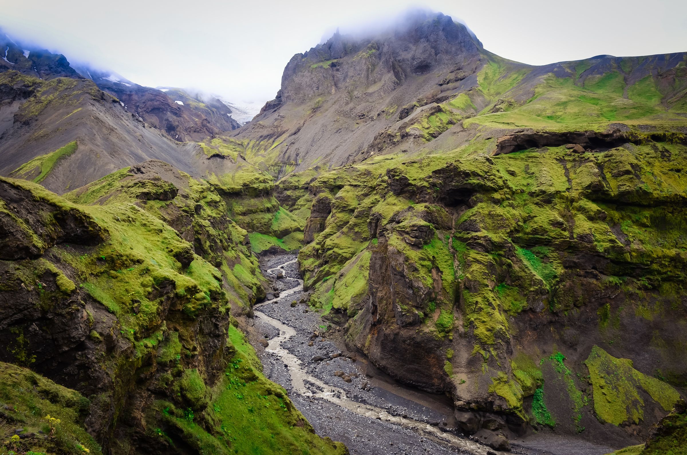 une rivière qui coule à travers un canyon entre deux montagnes à Þórsmörk en Islande.