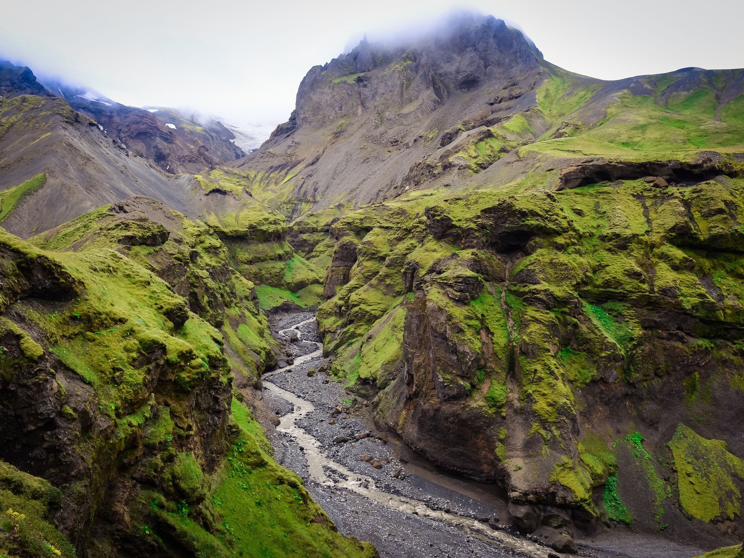 une rivière qui coule à travers un canyon entre deux montagnes à Þórsmörk en Islande.