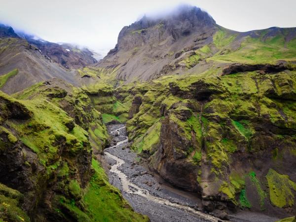 une rivière qui coule à travers un canyon entre deux montagnes à Þórsmörk en Islande.