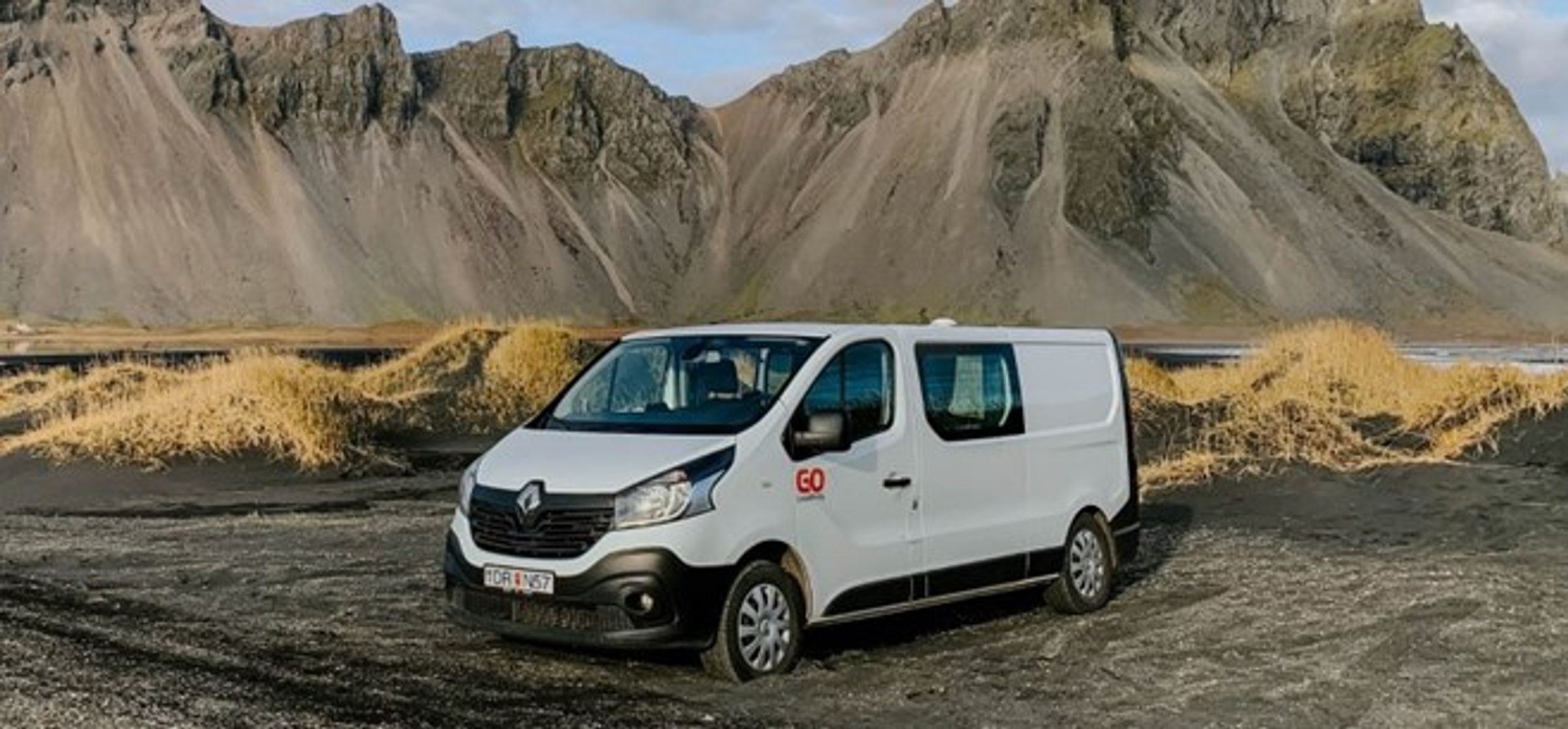 camper blanca en frente de una montaña