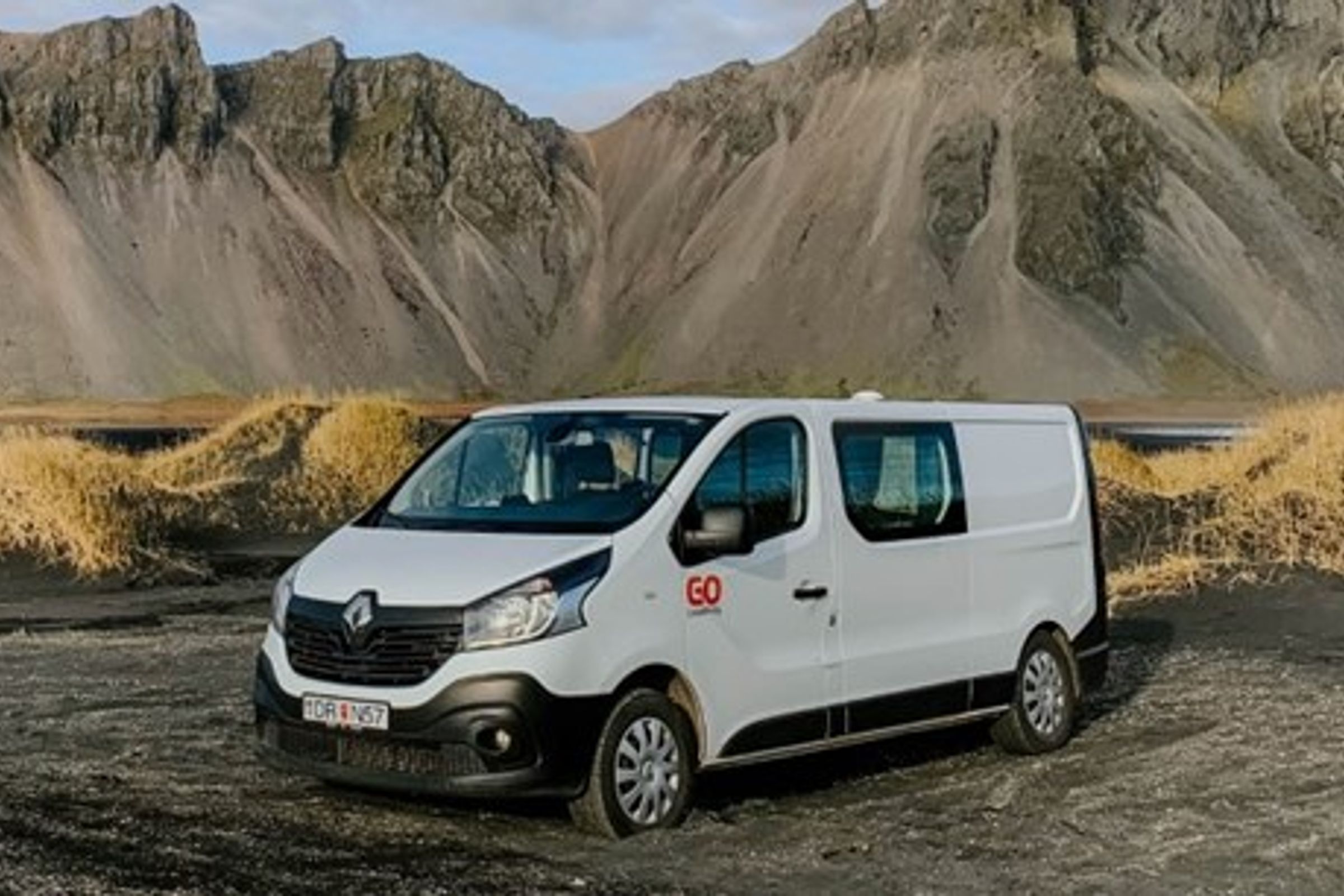 camper blanca en frente de una montaña