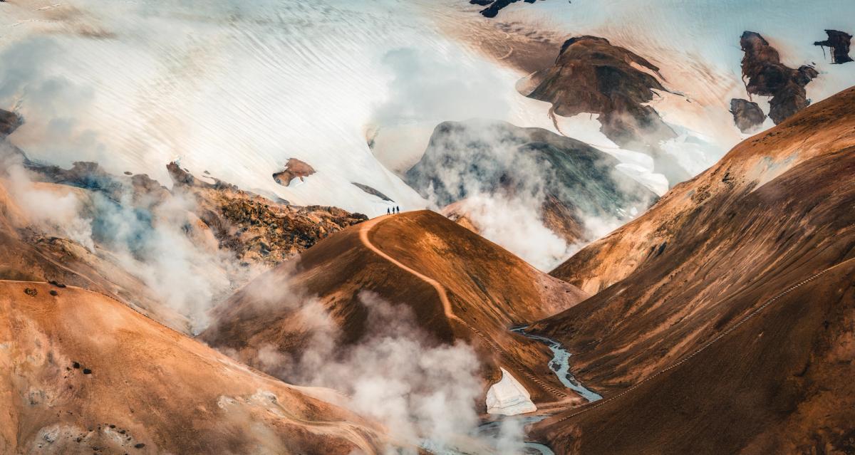 a group of people standing on top of a mountain surrounded by clouds at Kerlingafjöll in iceland.