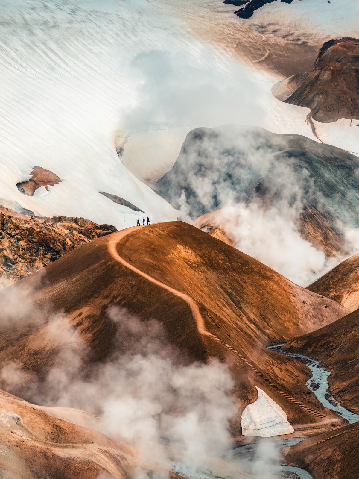 a group of people standing on top of a mountain surrounded by clouds at Kerlingafjöll in iceland.