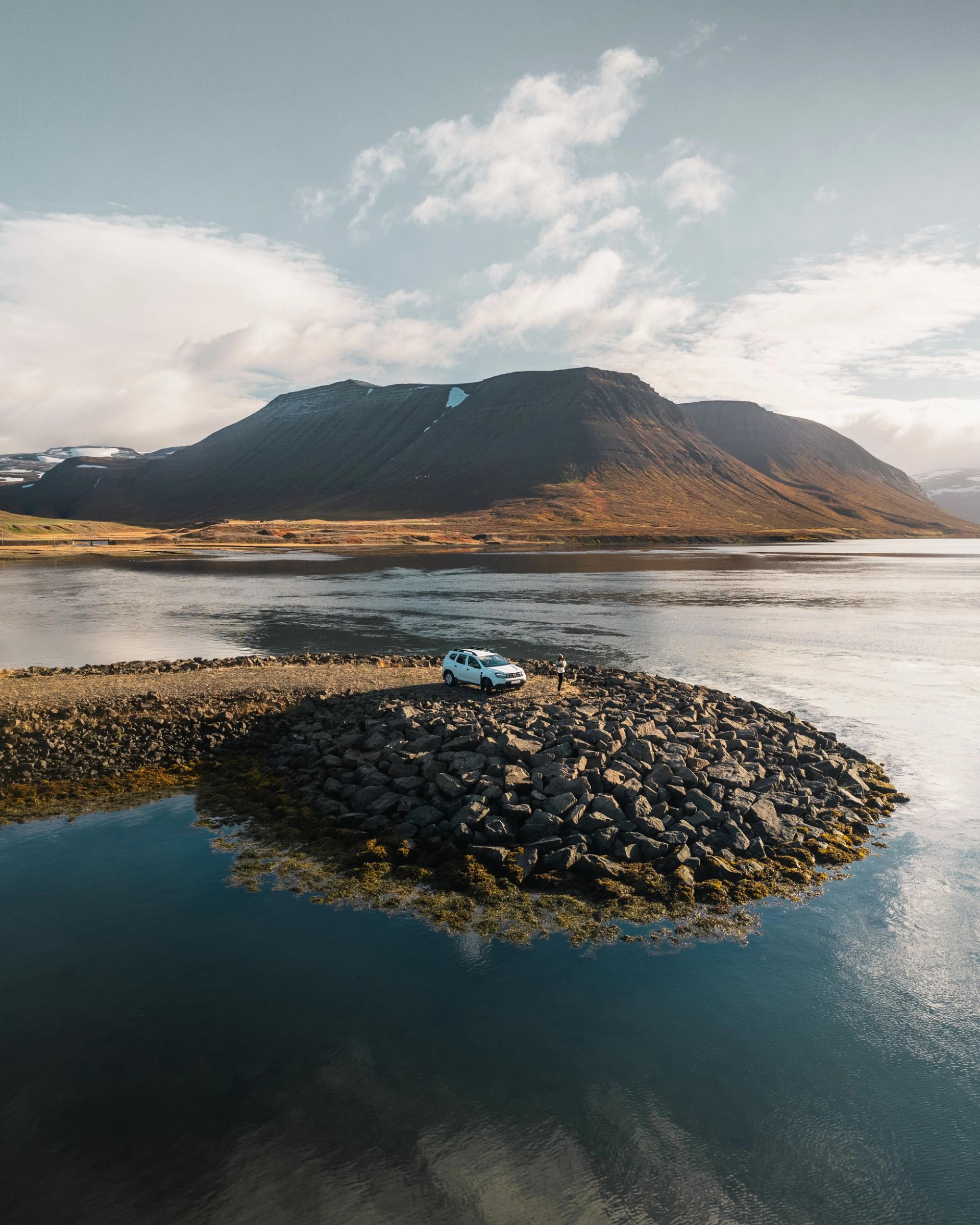 Coche blanco en el borde de un lago en Islandia