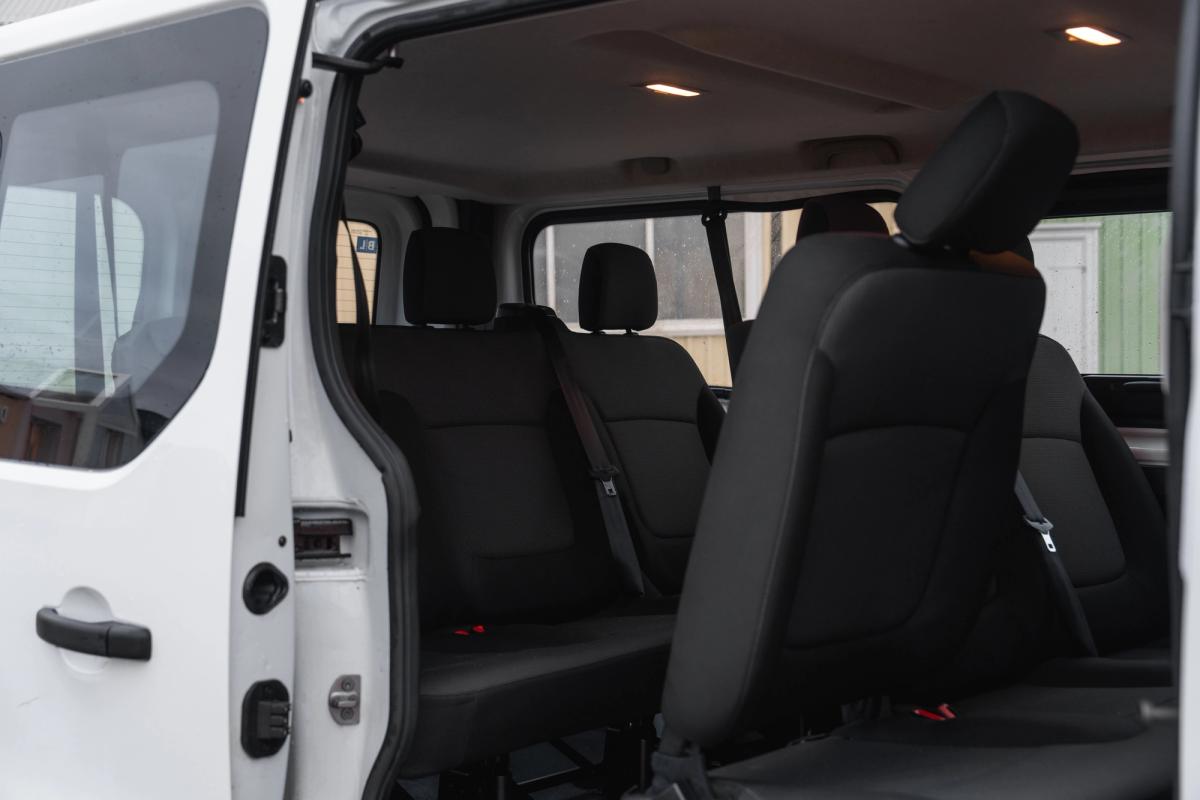 Vista del interior de una minivan Renault Trafic, con los asientos de la fila central vistos a través de la puerta abierta