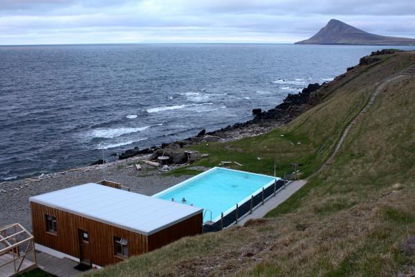 Krossneslaug a large swimming pool is sitting on top of a hill next to the ocean .