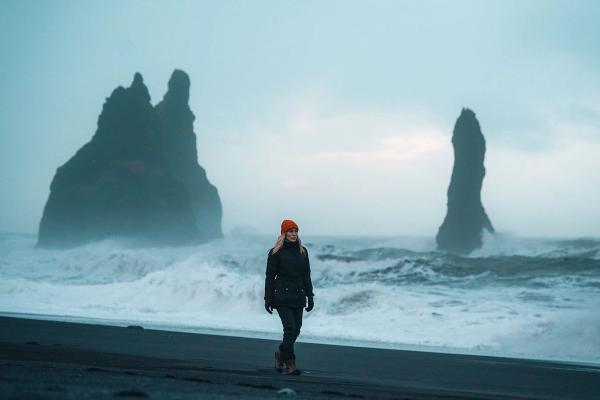 Woman in Black sand beach iceland A woman walking on a black sand beach in iceland