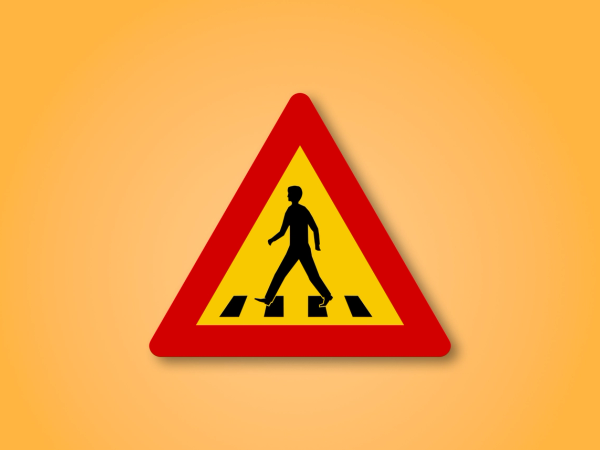 a yellow and red sign shows a man crossing a crosswalk