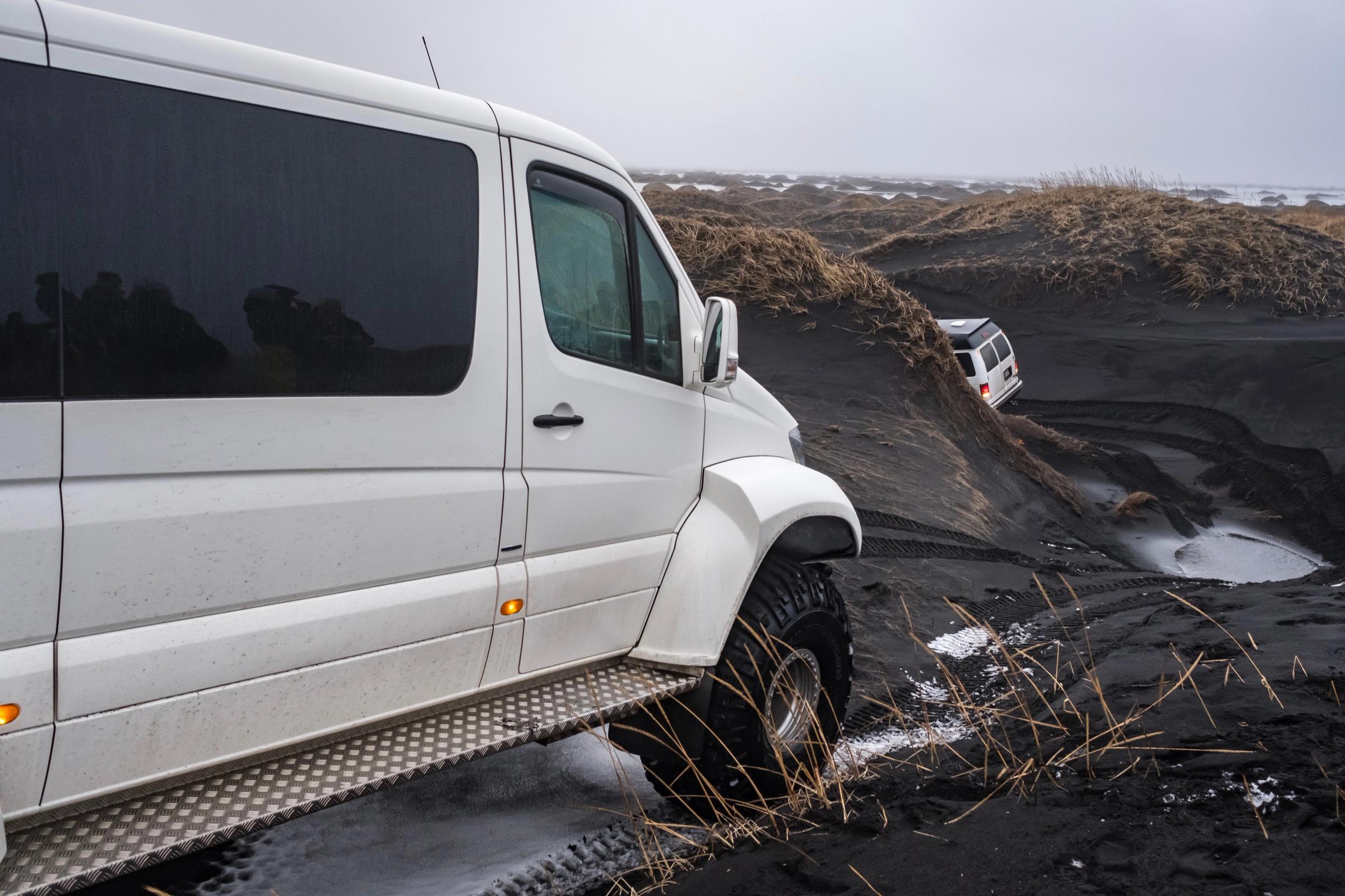 dos super jeep blancos en arena negra volcánica