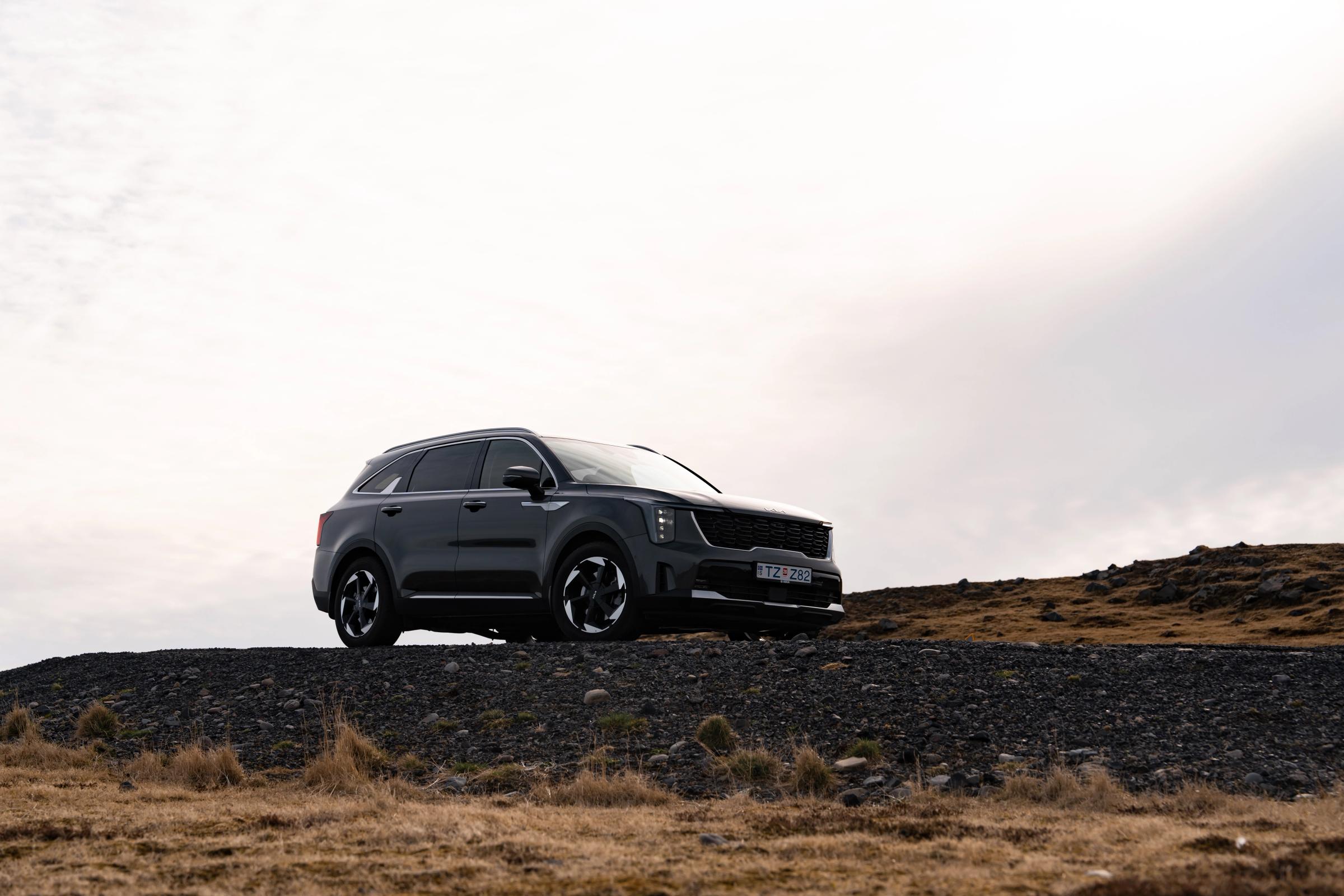 Kia Sorento garé dans un vaste paysage de hauts plateaux, avec des collines au loin
