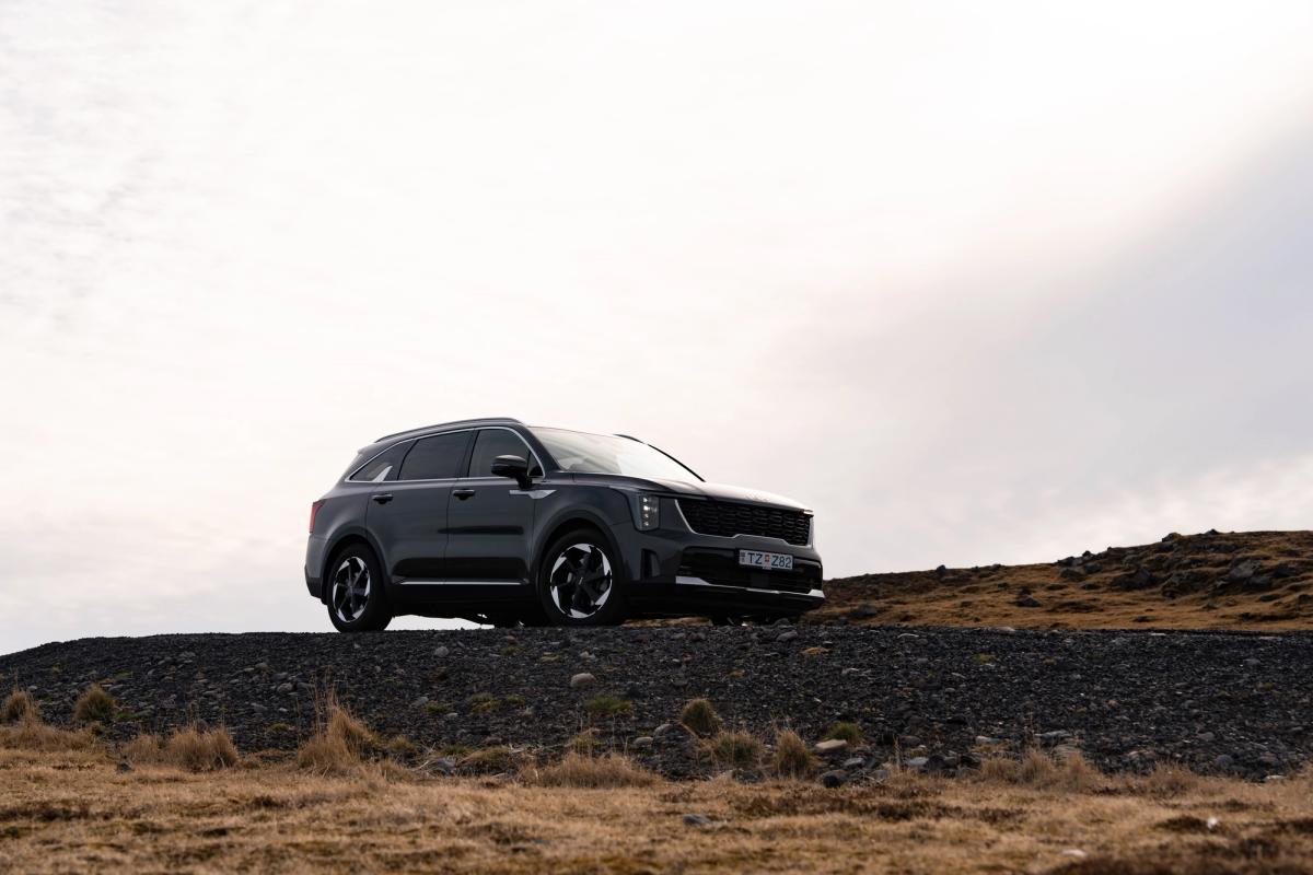 Kia Sorento garé dans un vaste paysage de hauts plateaux, avec des collines au loin