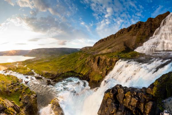 there is a waterfall in the middle of the mountains in iceland .
