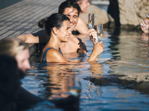 Couple drinking champagne in Hvammsvík Hot Springs