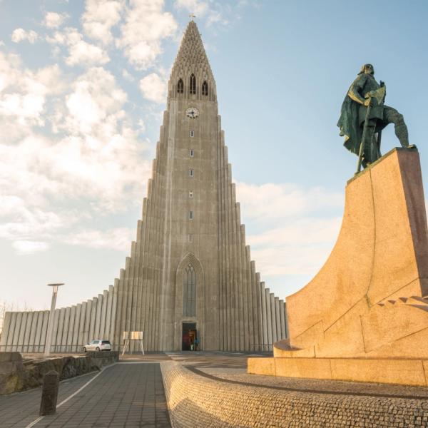 a large building with a clock tower and a statue in front of it .