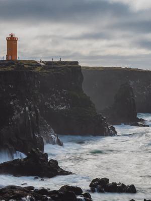 a lighthouse on top of a cliff overlooking the ocean .