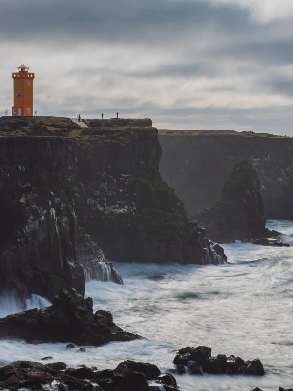 un faro en lo alto de un acantilado con vistas al océano .