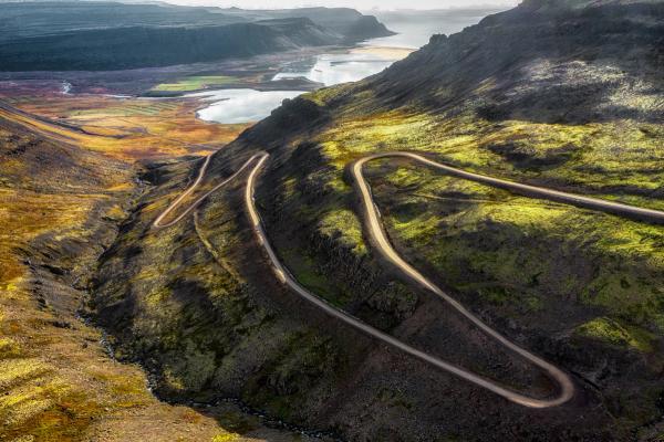 an aerial view of a winding road in the mountains .