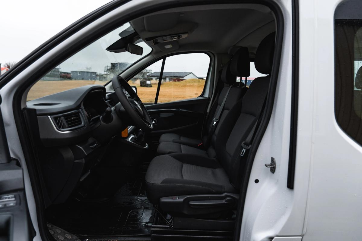 Vista interior de una miniván Renault Trafic, con los asientos delanteros vistos a través de la puerta corredera abierta