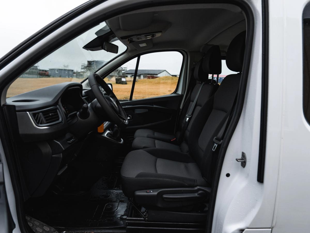 Vista de los asientos delanteros del Trafic Vista interior de una miniván Renault Trafic, con los asientos delanteros vistos a través de la puerta corredera abierta