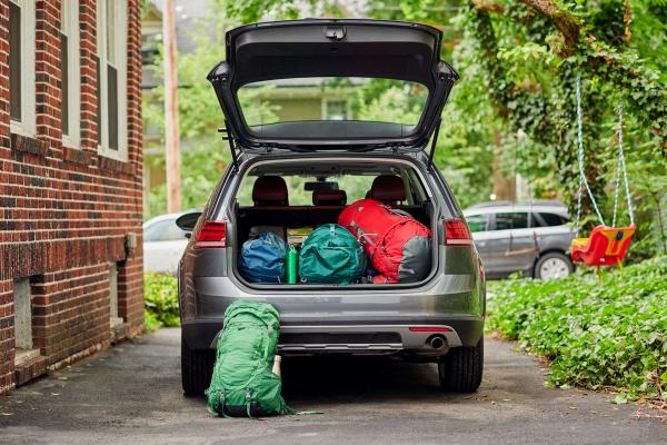 the trunk of a car is filled with backpacks and luggage .