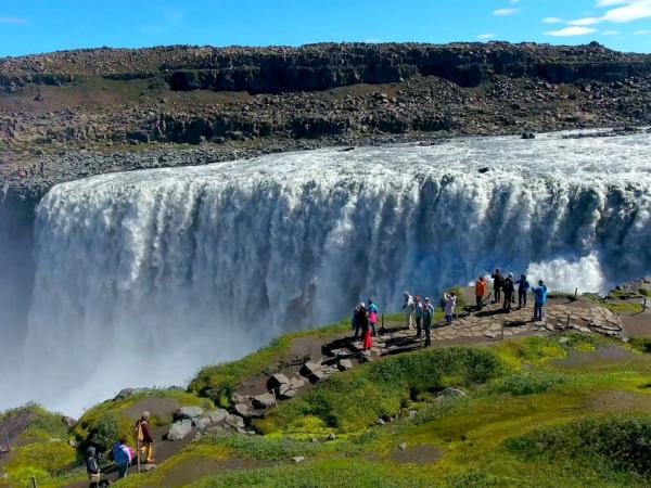 Un grupo de gente viendo la cascada de Dettifoss