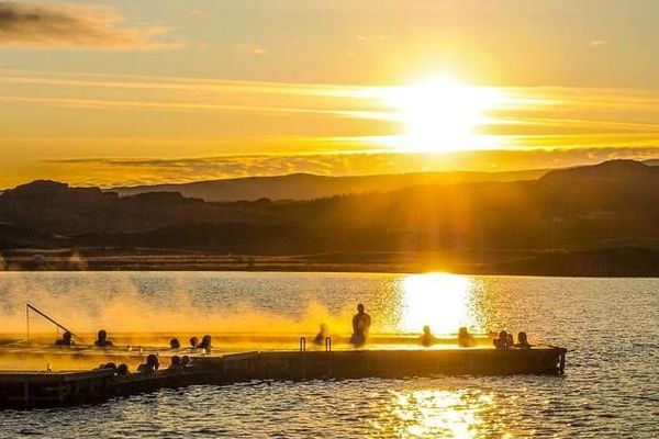 Group of people at Vök Baths during sunset