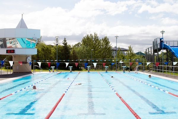 a large swimming pool with a water slide in the background .
