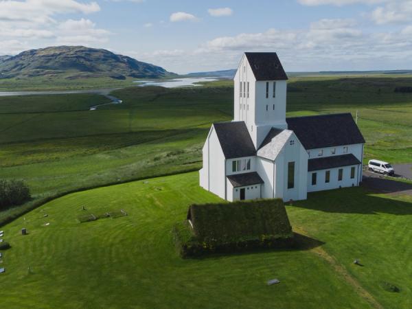 an aerial view of a white church in the middle of a grassy field .