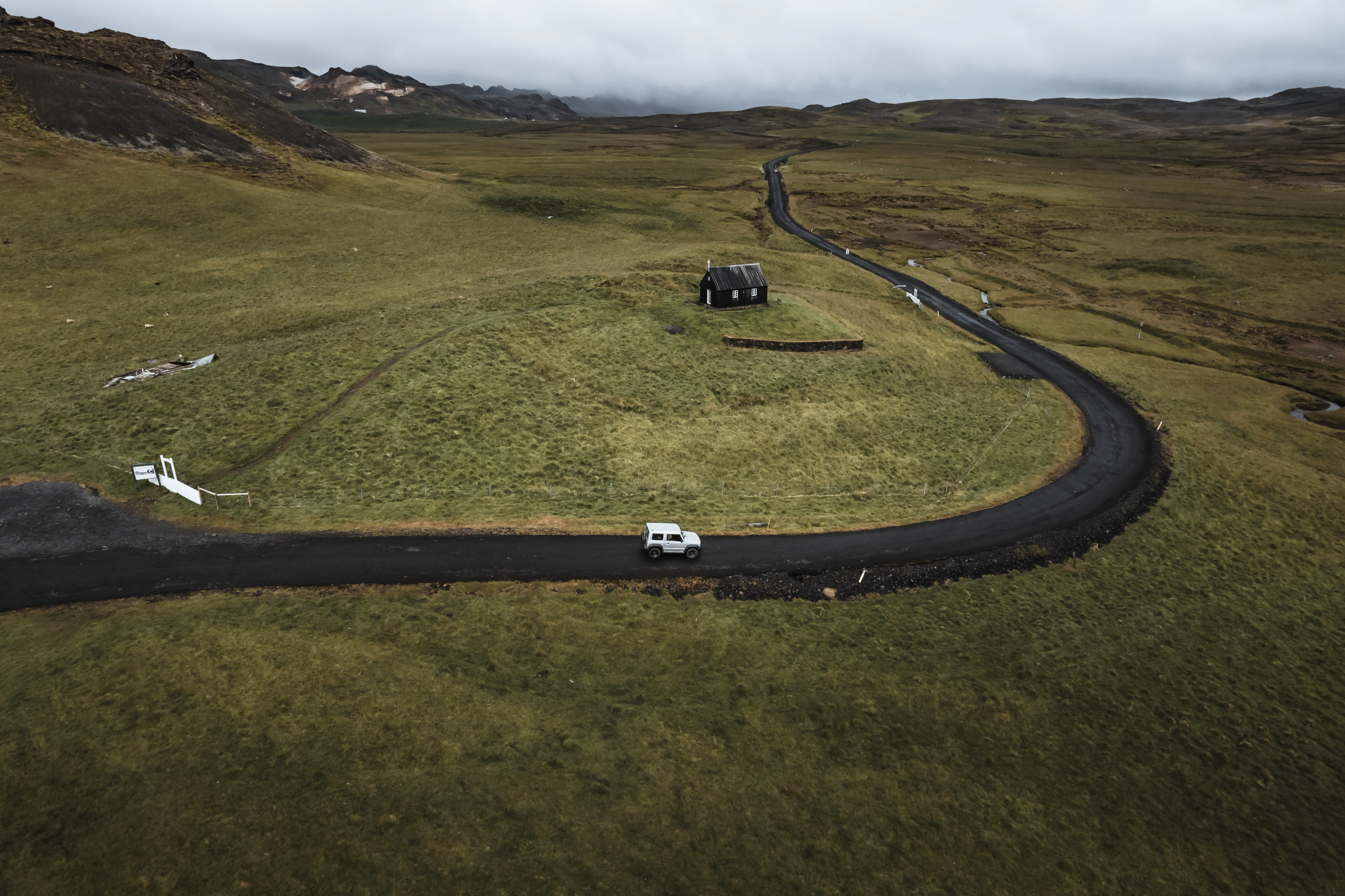 a white van is driving down a curvy road