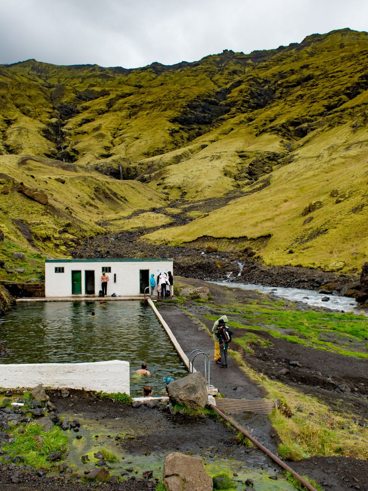 La piscina natural Seljavallalaug en Islandia Una piscina termal en medio de un valle verde