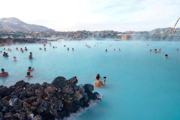 a group of people are swimming in a large body of water .