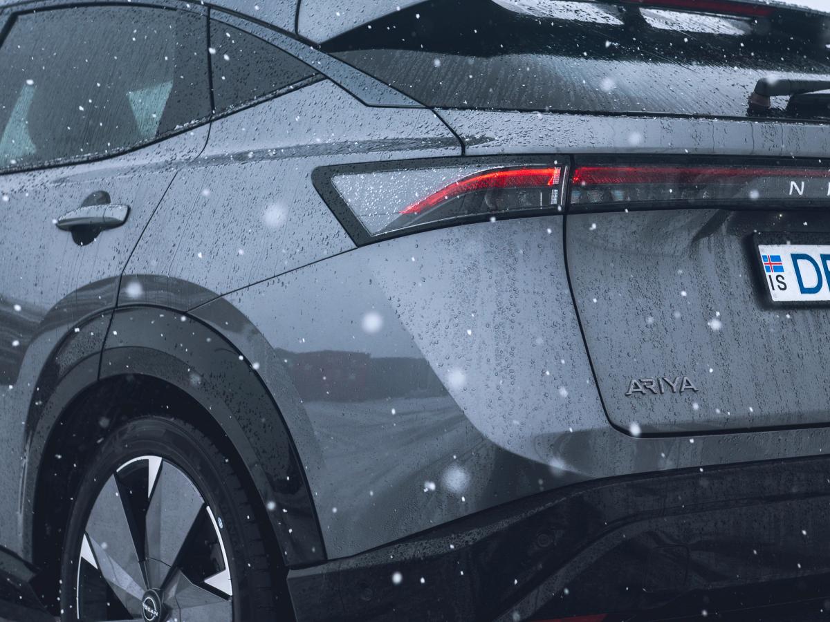 Nissan Ariya – smáatriði að aftan Nærmynd af afturhluta Nissan Ariya sem er lagt í opnu hálendislandslagi