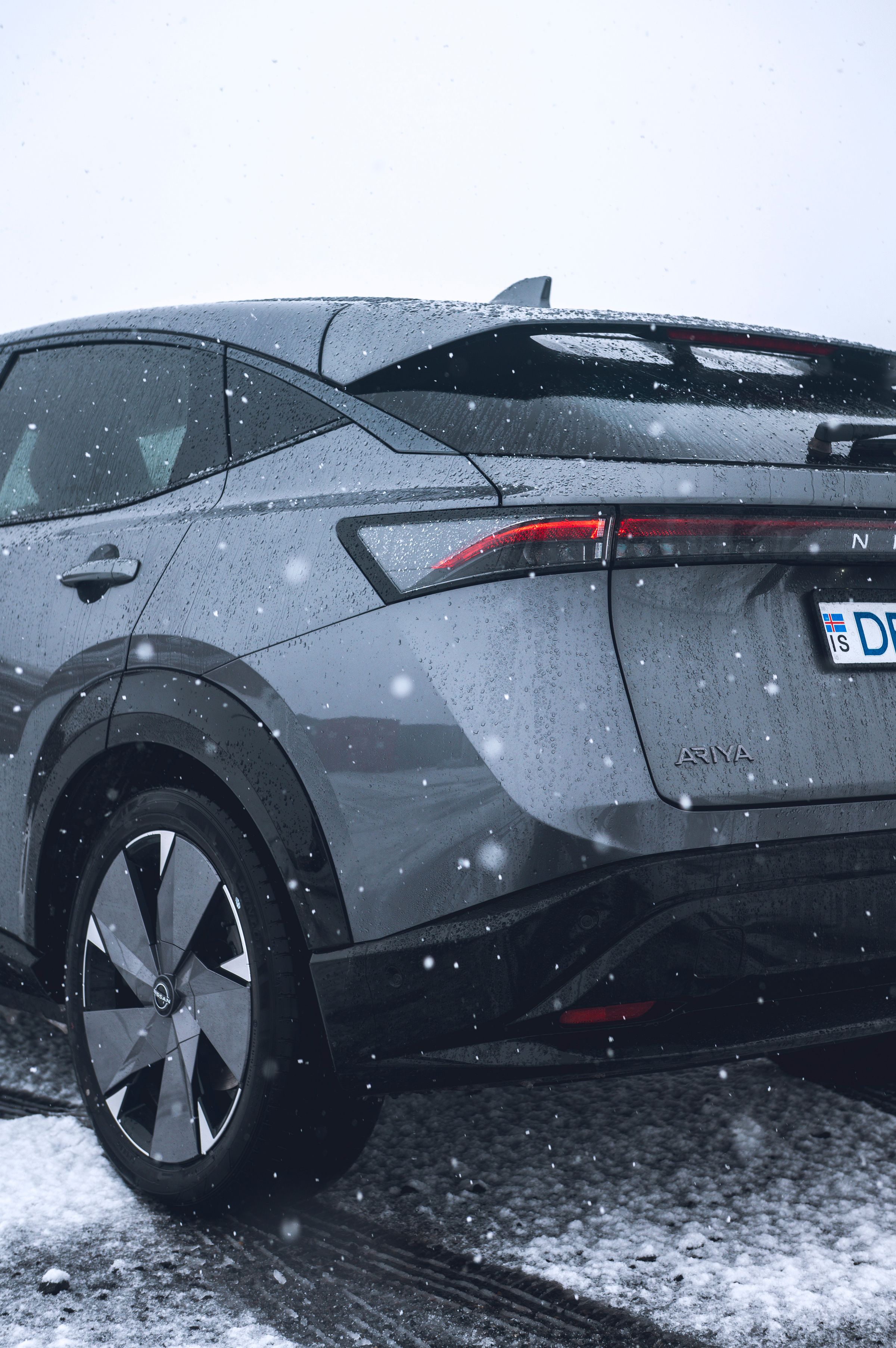 Nissan Ariya – smáatriði að aftan Nærmynd af afturhluta Nissan Ariya sem er lagt í opnu hálendislandslagi