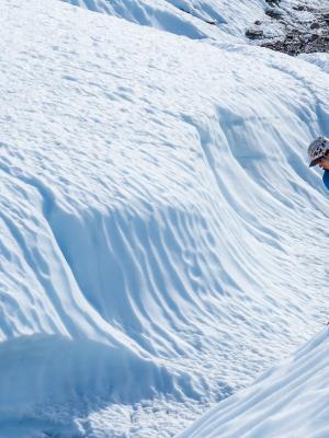 a person is climbing a snowy mountain with a rope .