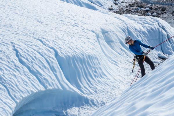 A climber rappelling down a glacier.