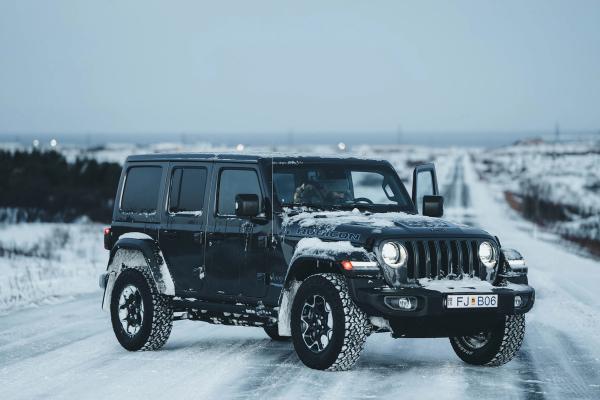 Jeep Wrangler Rubicon Jeep Wrangler 4x4 rental car iceland parked on a snowy road