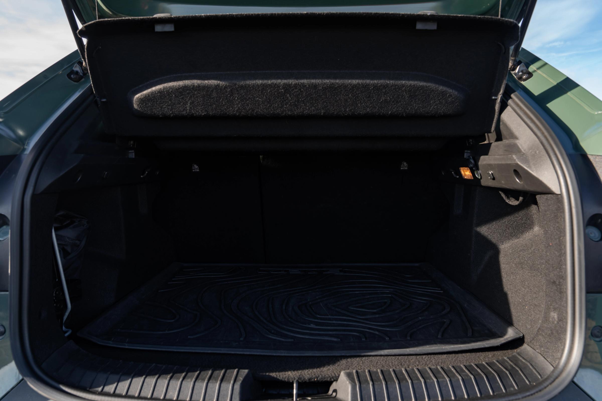 Porta-bagagens aberto de um Dacia Duster, com tapete de borracha e chapeleira levantada