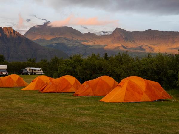 orange tents with mountains on the background