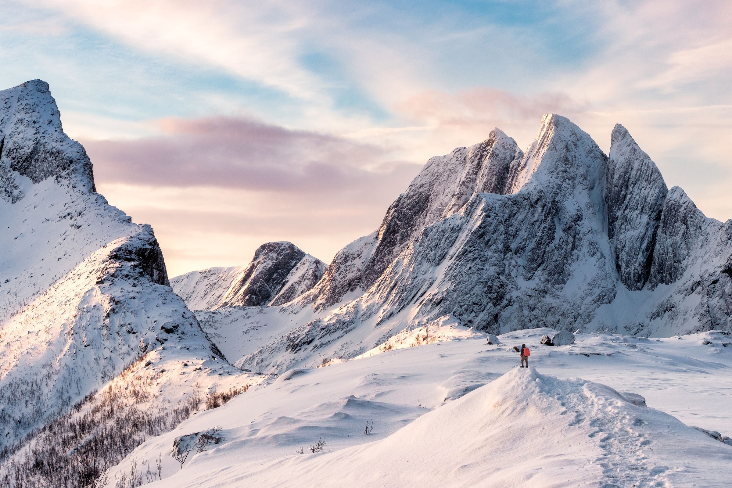 two people are standing on top of a snow covered mountain .