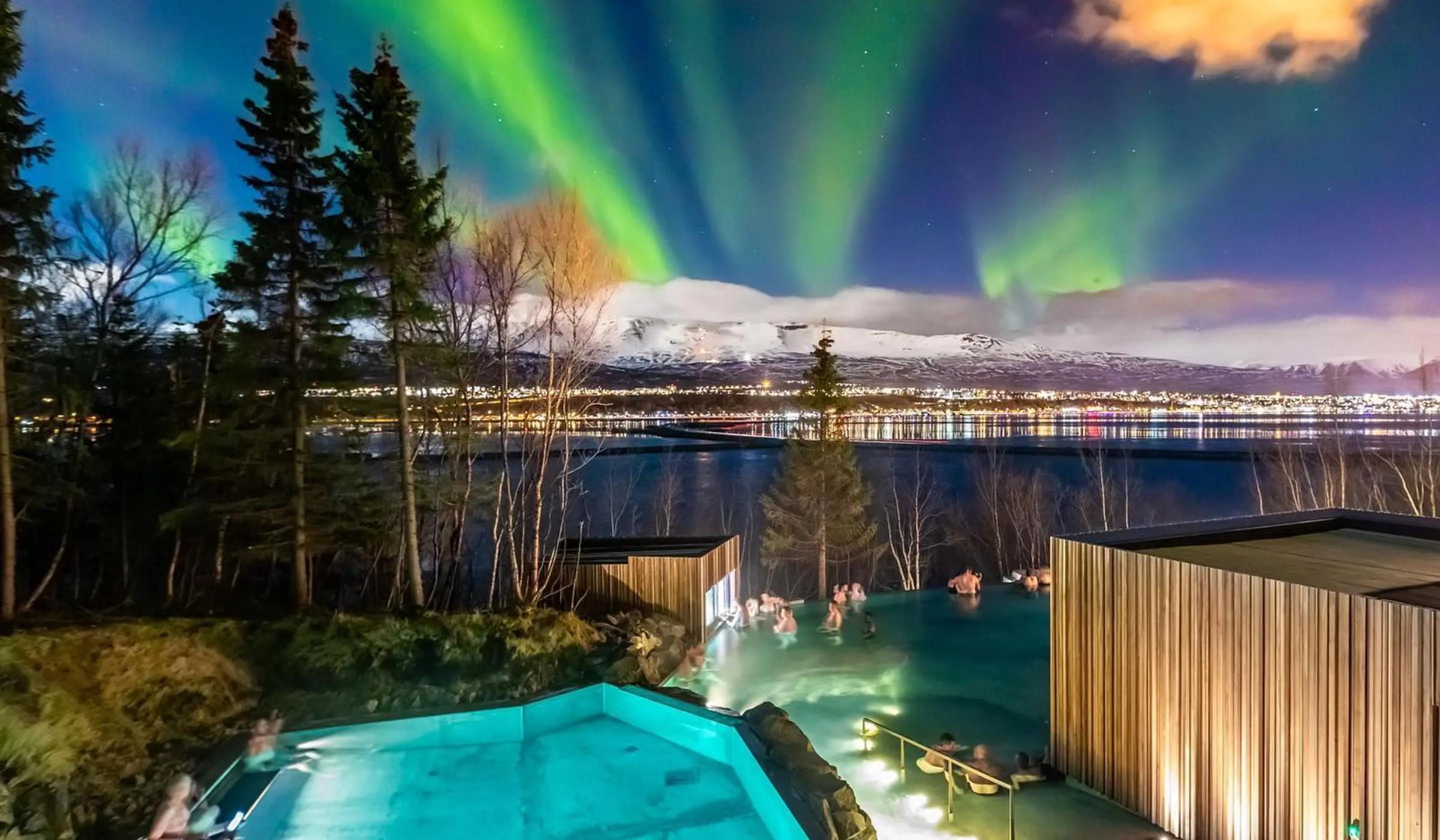 se pueden ver las auroras boreales sobre una piscina por la noche.