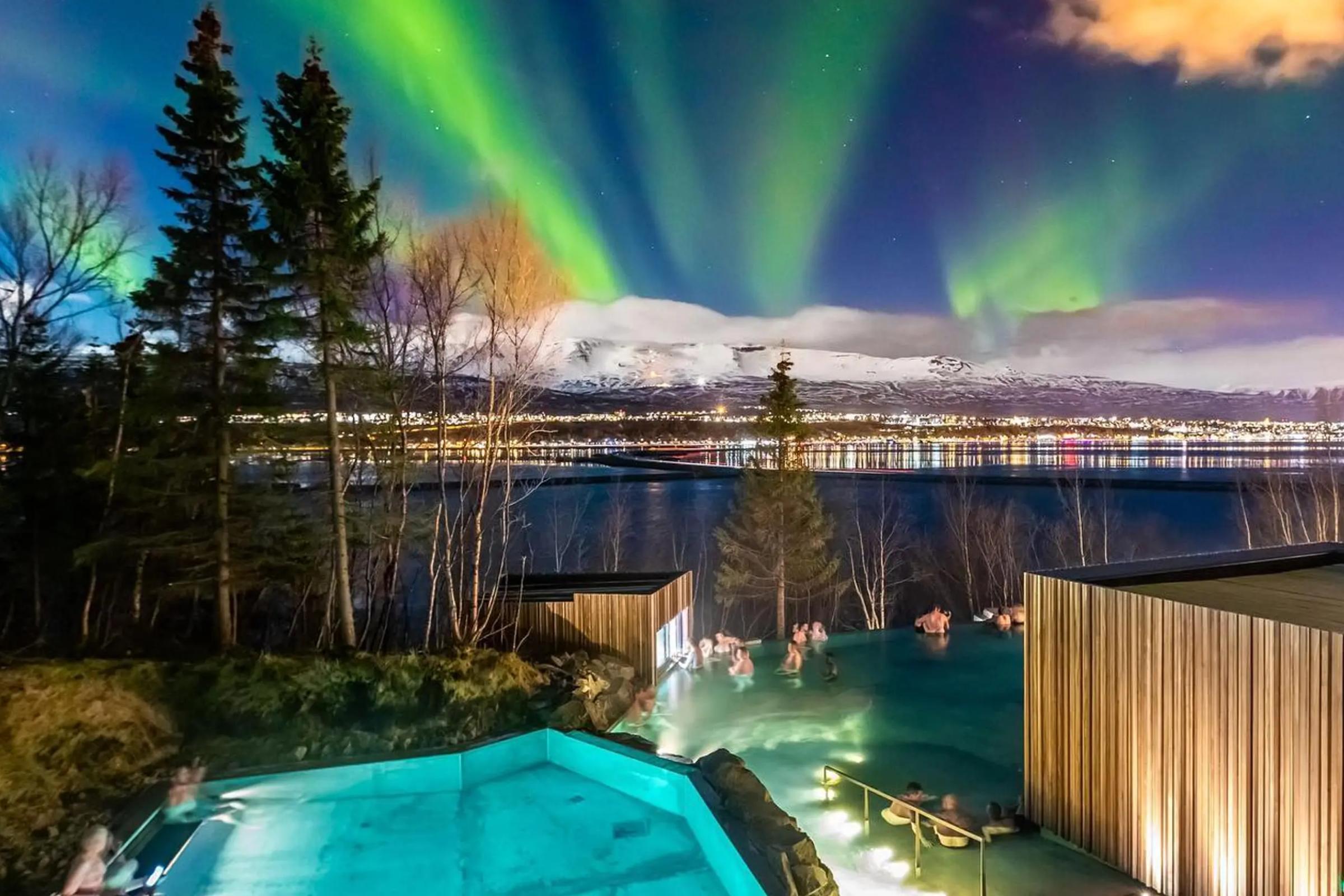 se pueden ver las auroras boreales sobre una piscina por la noche.