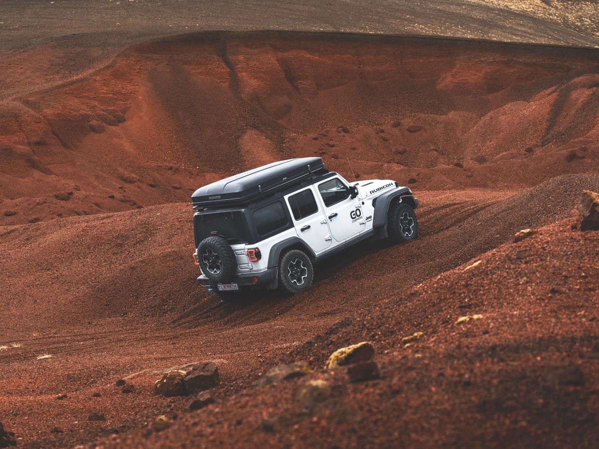 4x4 húsbíll Red Hills Fjórhjóladrifinn húsbíll með svefnplássi fyrir fjóra ekur um rauðleitar malarhæðir, húsbílaleiga á Íslandi