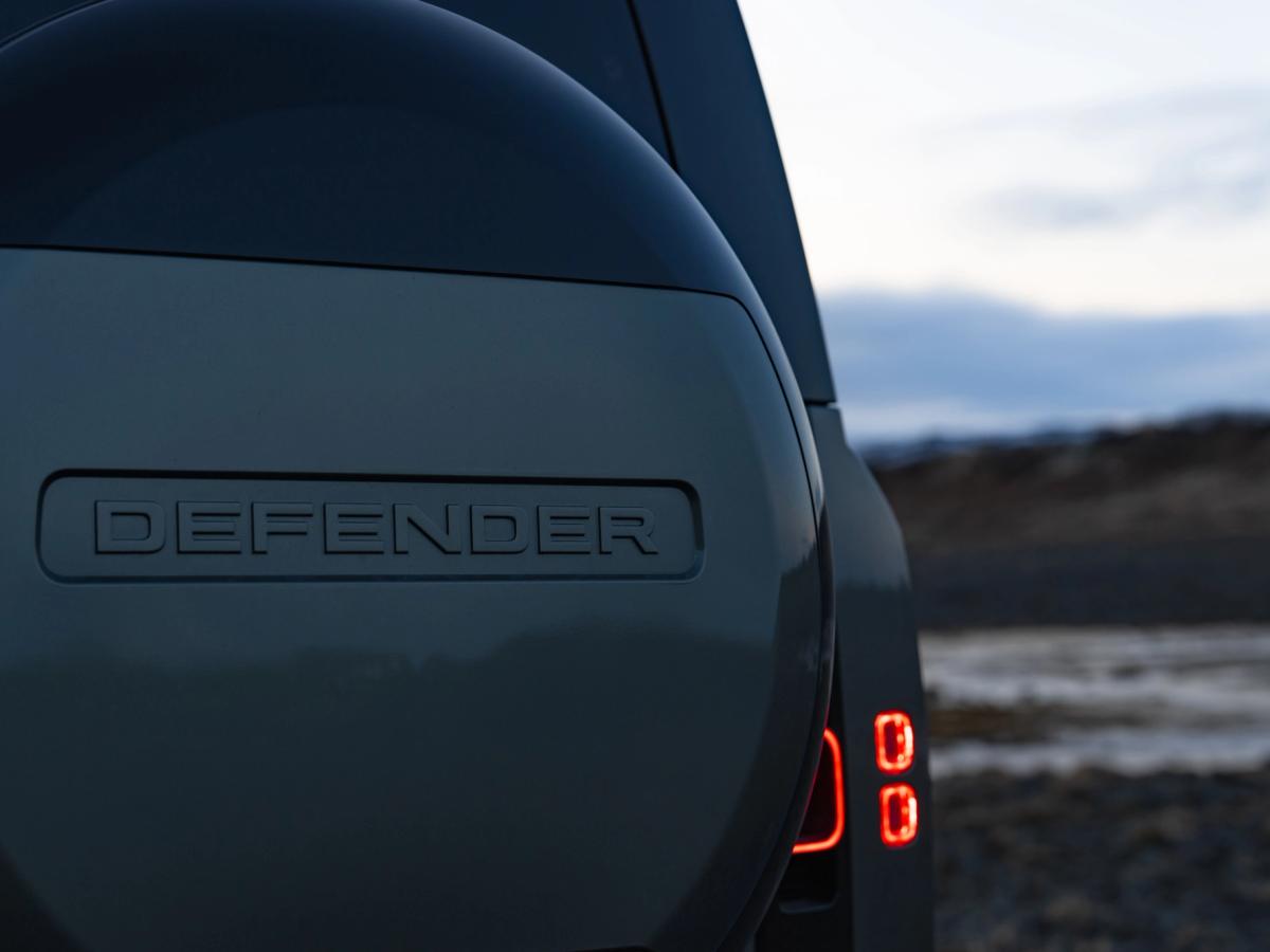 Rueda de repuesto trasera y piloto trasero del Defender Primer plano de la rueda de repuesto trasera y el piloto trasero de un Land Rover Defender de alquiler en Islandia, disponible en Go Car Rental