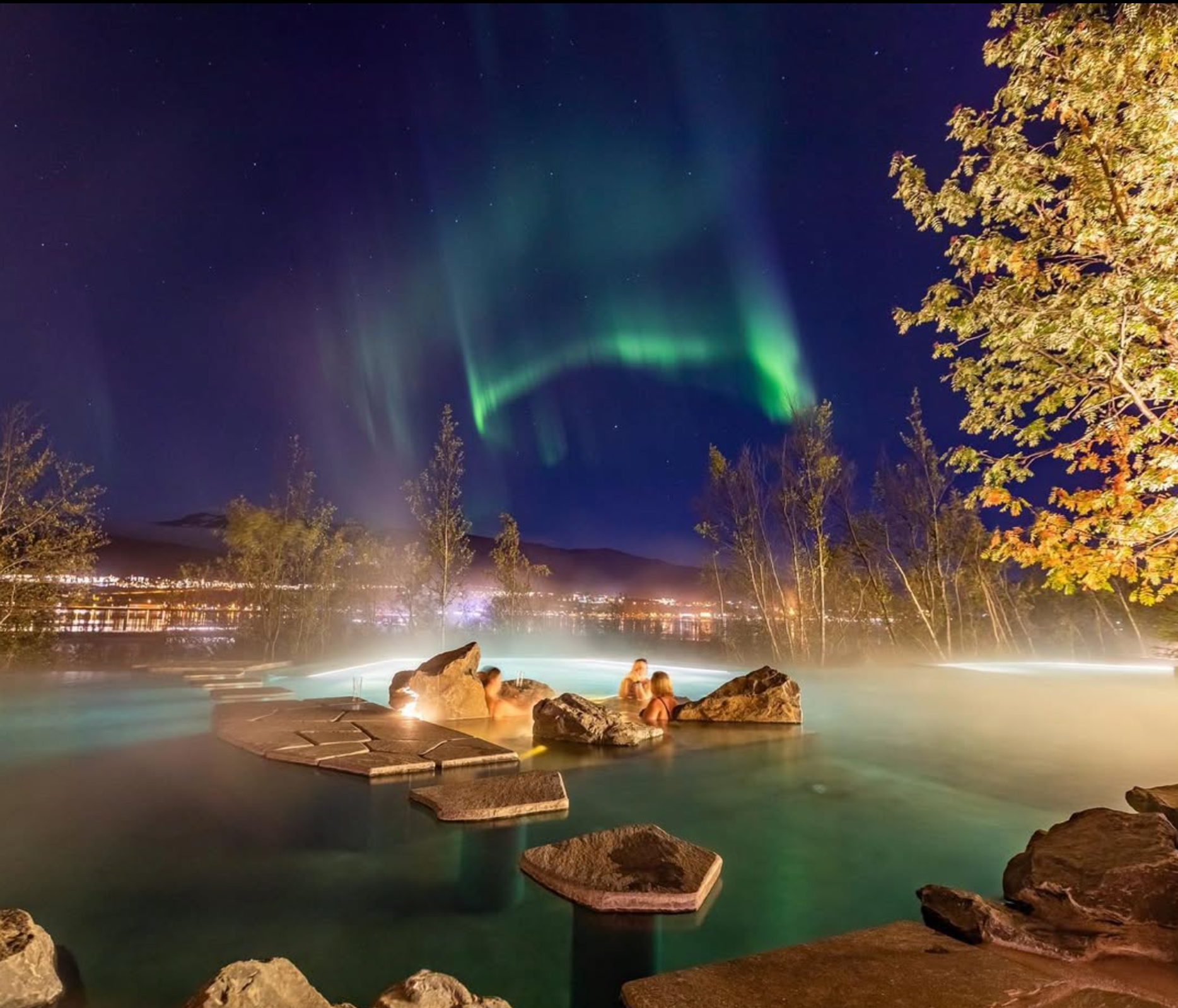 las auroras boreales son visibles en el cielo nocturno sobre un jacuzzi