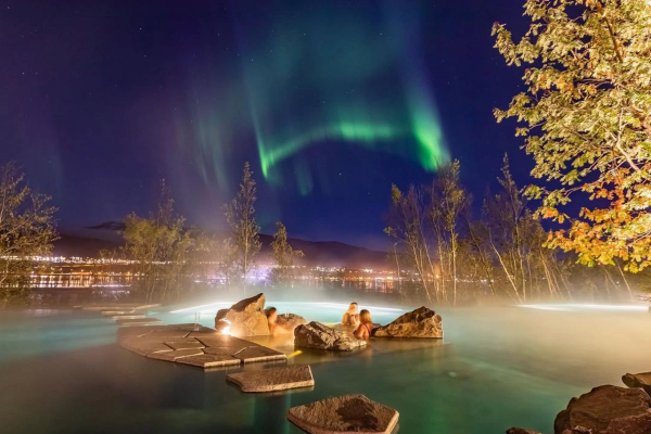 las auroras boreales son visibles en el cielo nocturno sobre un jacuzzi
