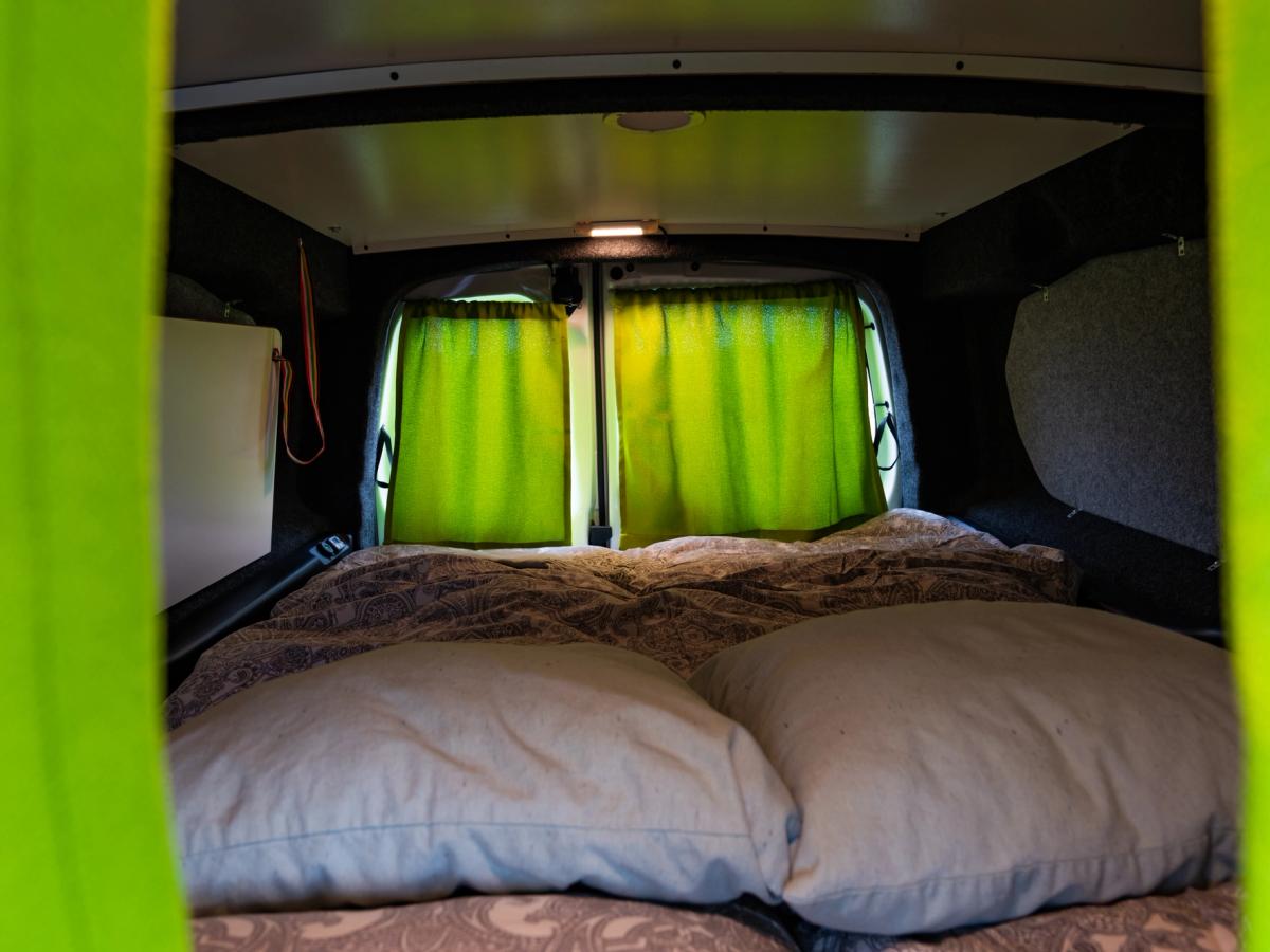 Vista de la plataforma desde la cabina Cama vista desde la cabina, con almohadas delante y las cortinas cerradas sobre las ventanas traseras