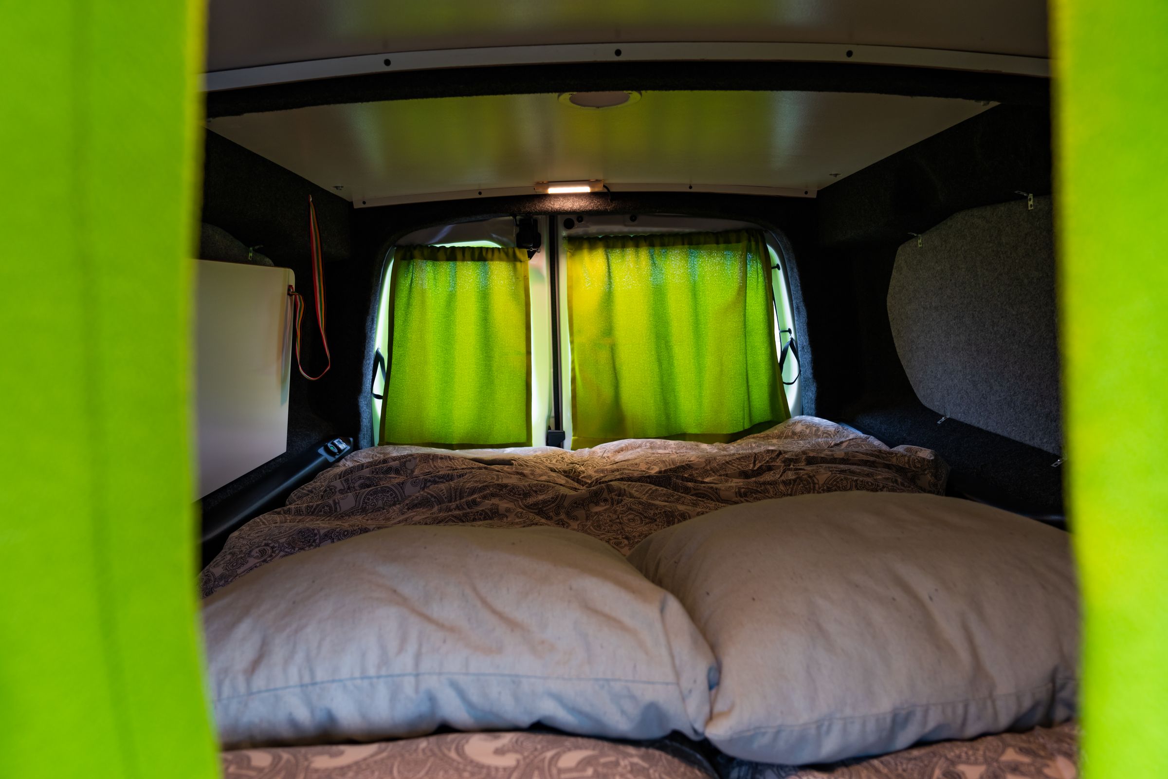 Vista de la plataforma desde la cabina Cama vista desde la cabina, con almohadas delante y las cortinas cerradas sobre las ventanas traseras