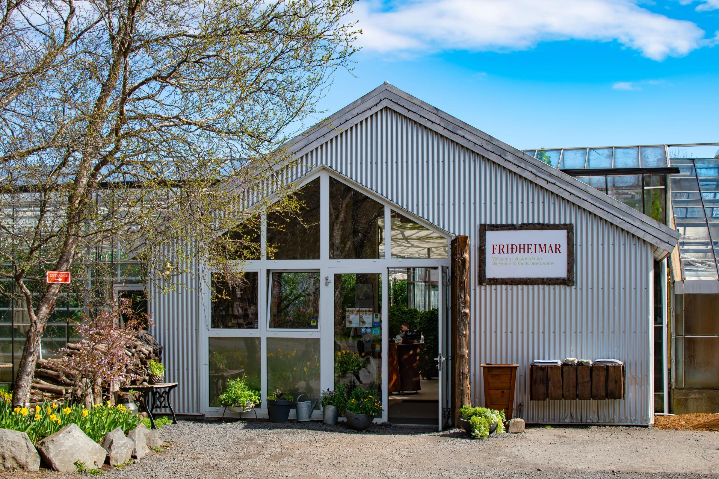 Entrée d'une serre avec l'enseigne "Friðheimar" à la porte