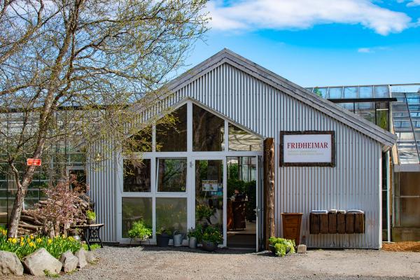 a large building with a lot of windows and plants in front of it .