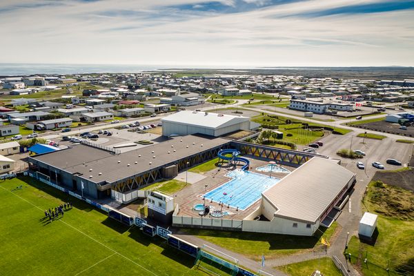 an aerial view of a swimming pool and a soccer field in a city .